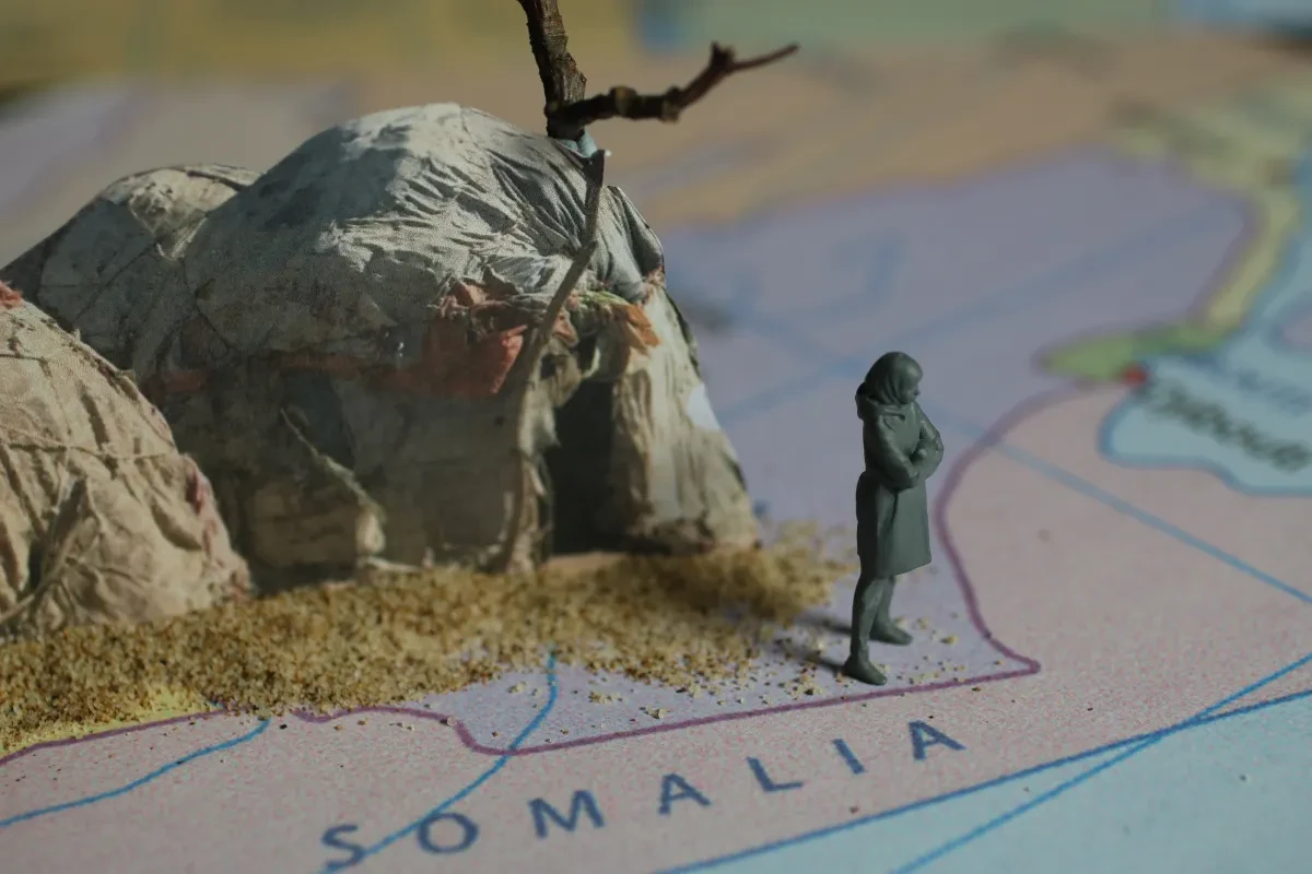 photo with a model of a woman, standing on a map and a canvas tent behind her, like an animation