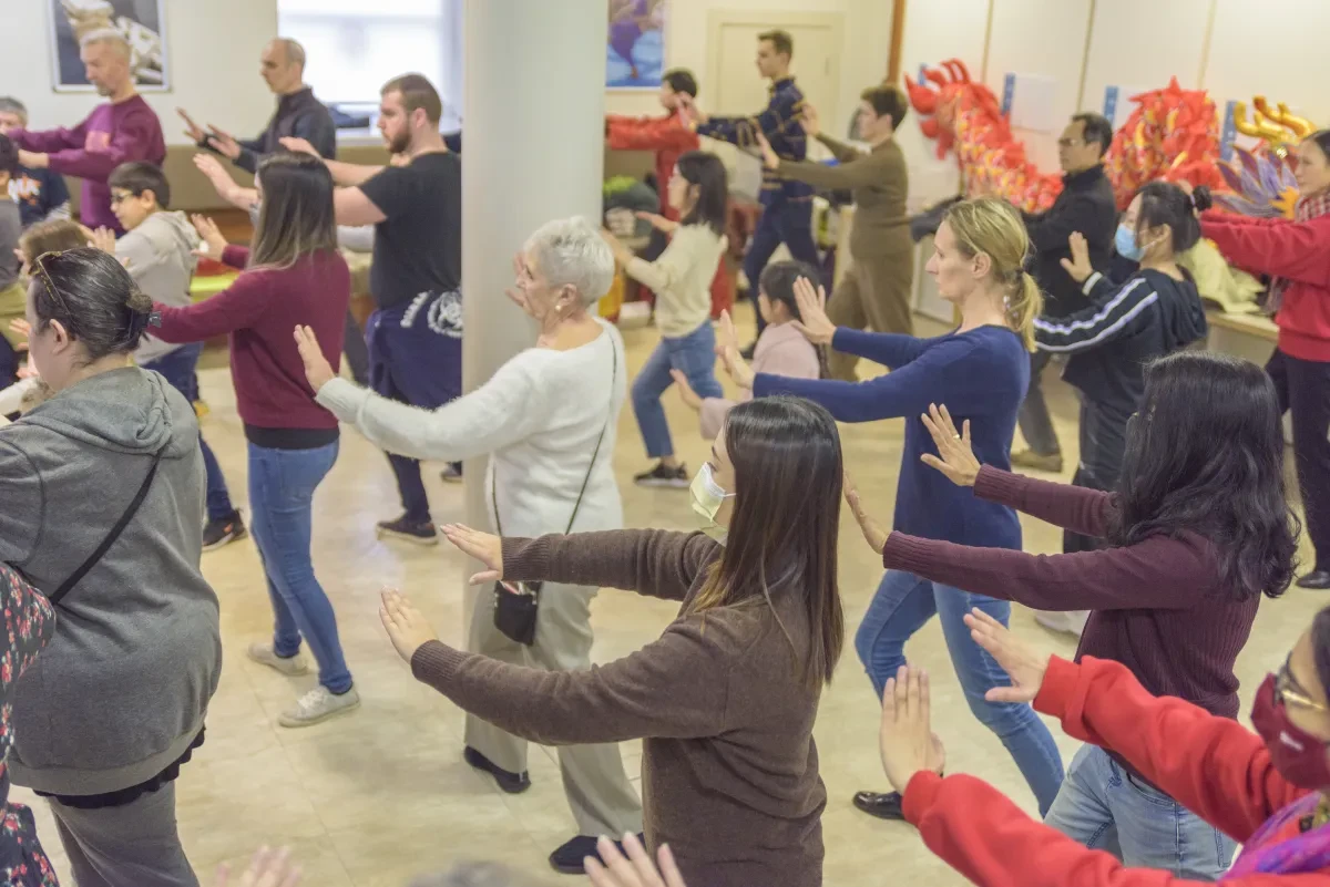 A group of people stretch their arms to the side