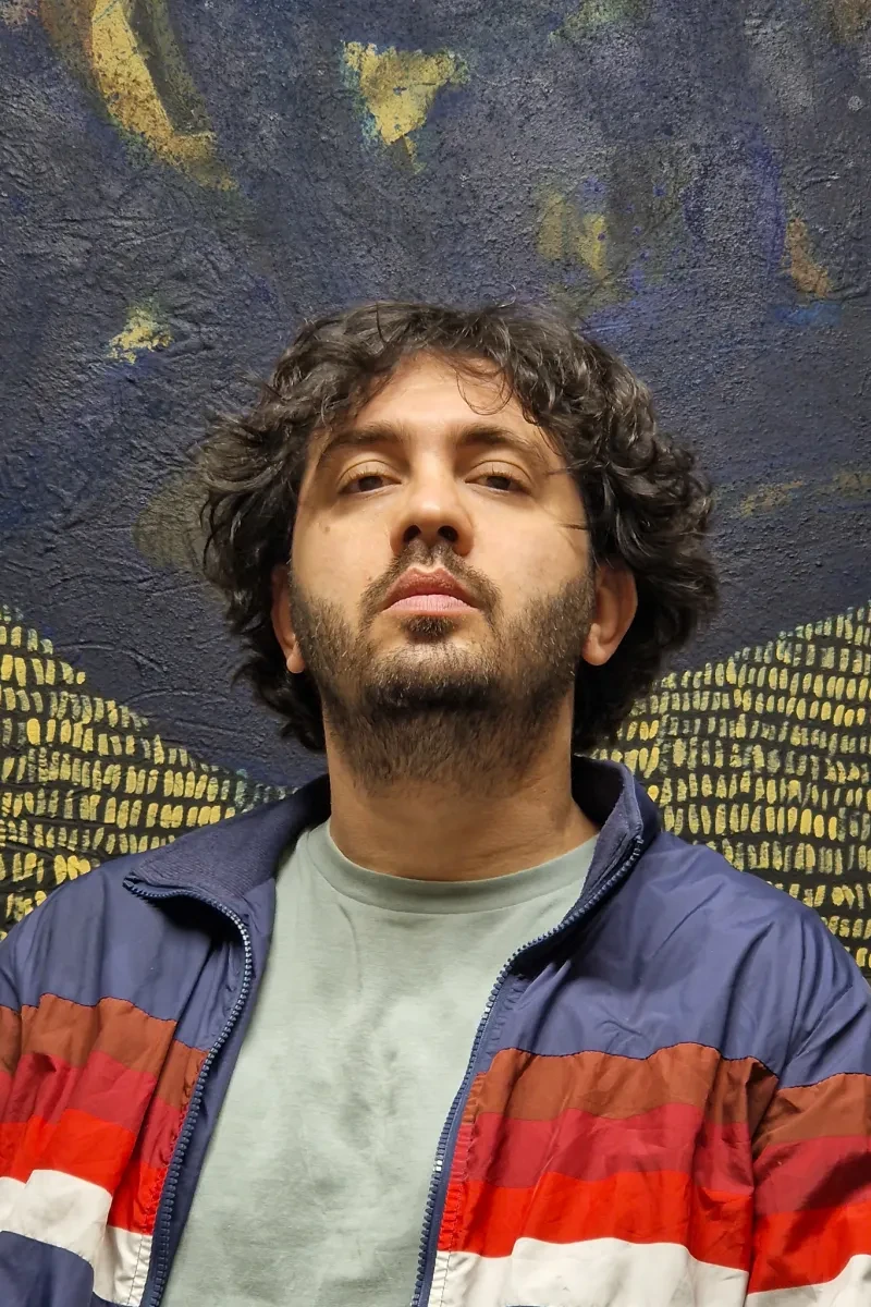 Headshot of Alaa Shasheet wearing a colourful jacket