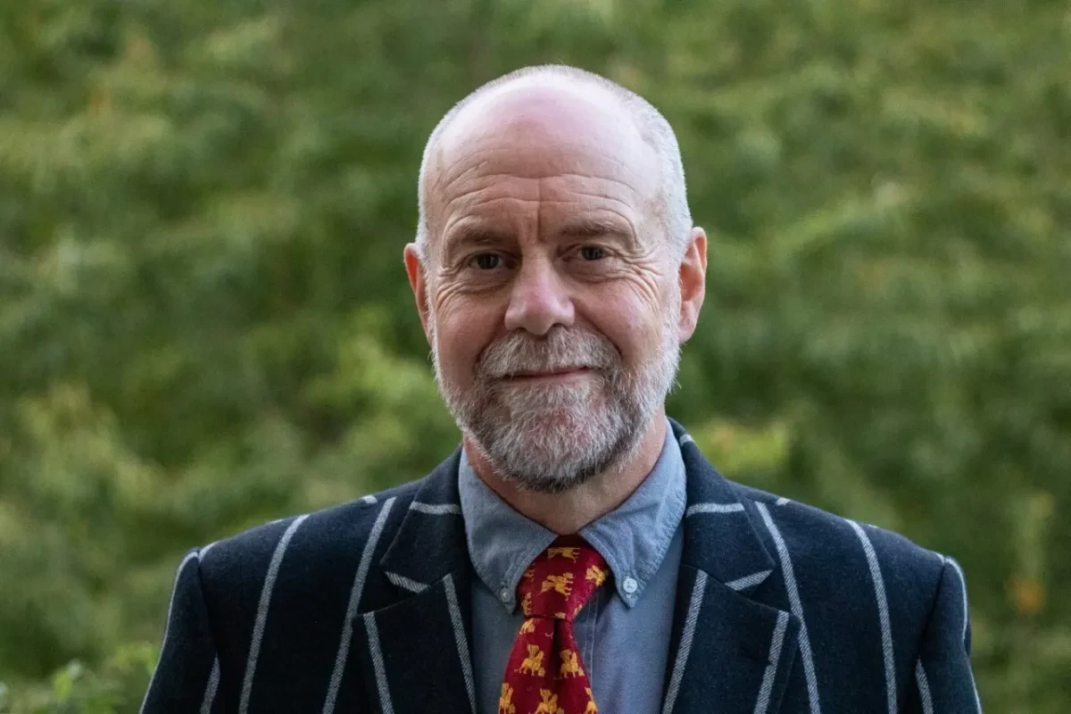 A portrait photograph of historian Andrew Lambert. He is wearing a dark pinstripe suit and red patterned tie