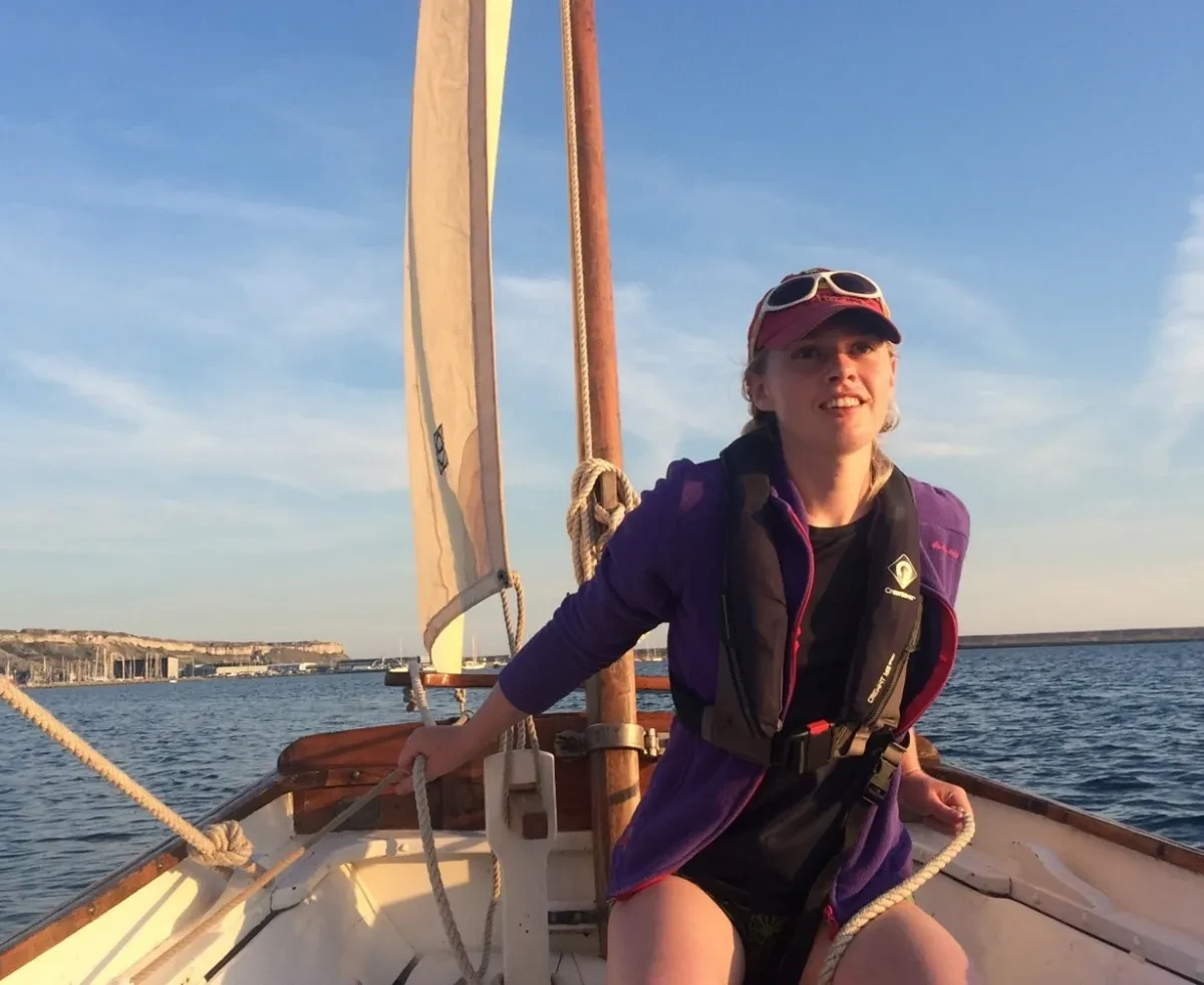 Photo of Maddie sitting on a sailing boat