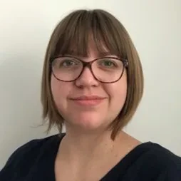 Astronomer Patricia Skelton smiles at the camera. She is wearing glasses and has light brown hair cut into a bob