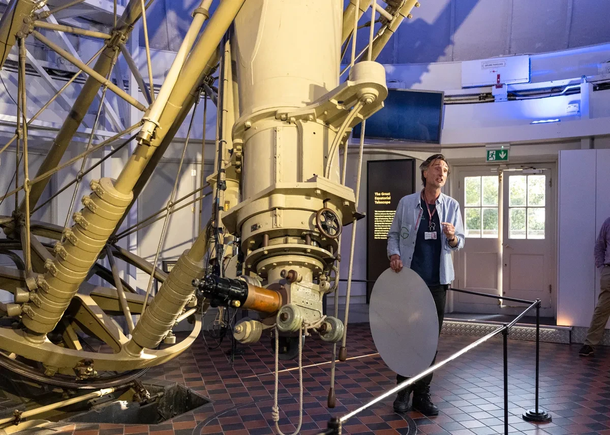 A tour guide gives a talk next to the Great Equatorial Telescope at the Royal Observatory