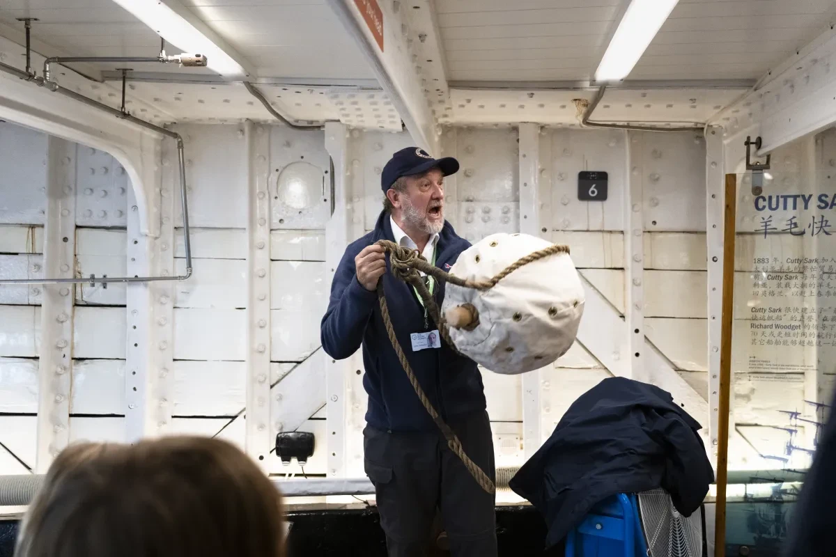 Volunteer giving talk holding life buoy on Cutty Sark