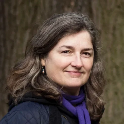Author Vanessa Taylor. She has dark brown mid-length hair, and wears a blue padded jacket and purple scarf