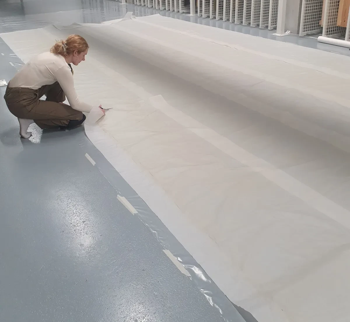 Collections officer unrolls a flag at The Prince Philip Maritime Collections Centre