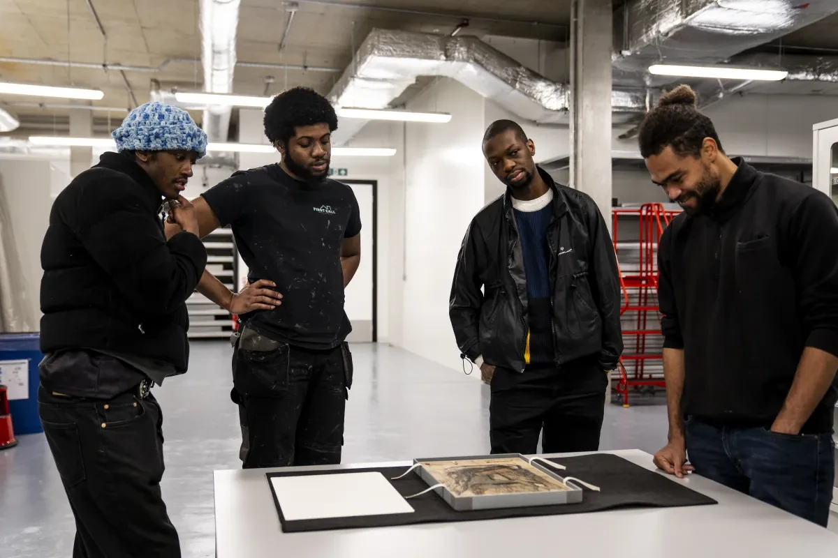 Group of four people look at a document at The Prince Philip Maritime Collections Centre