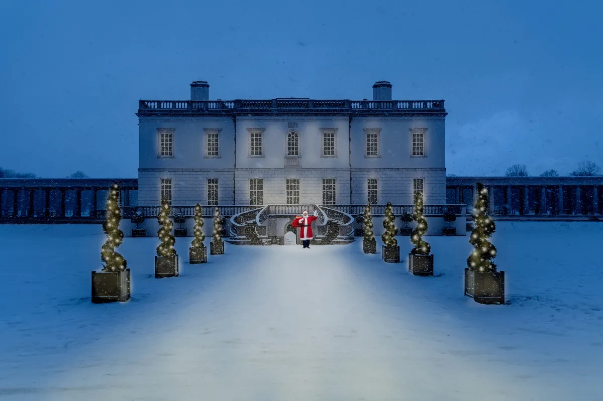 The Queen's House in the snow at night with Father Christmas at the entrance