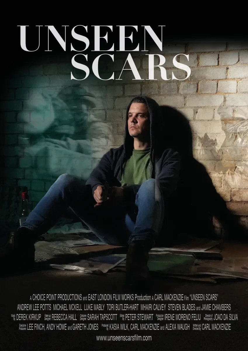 photo of a flyer for a film called Unseen Scars with a white man in a hoodie sitting on the ground against the wall, looking lost and anxious