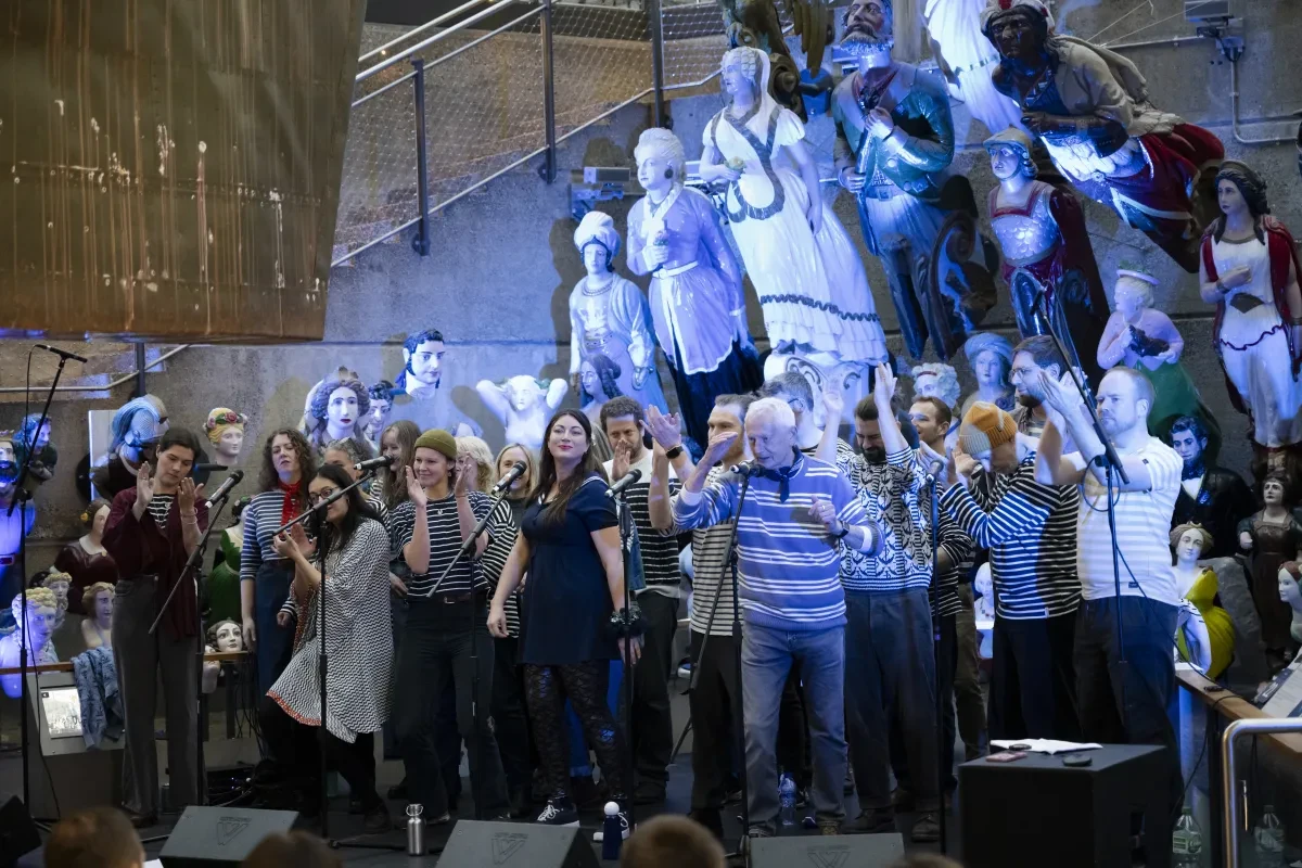 Photo of London Sea Shanty Collective in front of figureheads at Cutty Sark