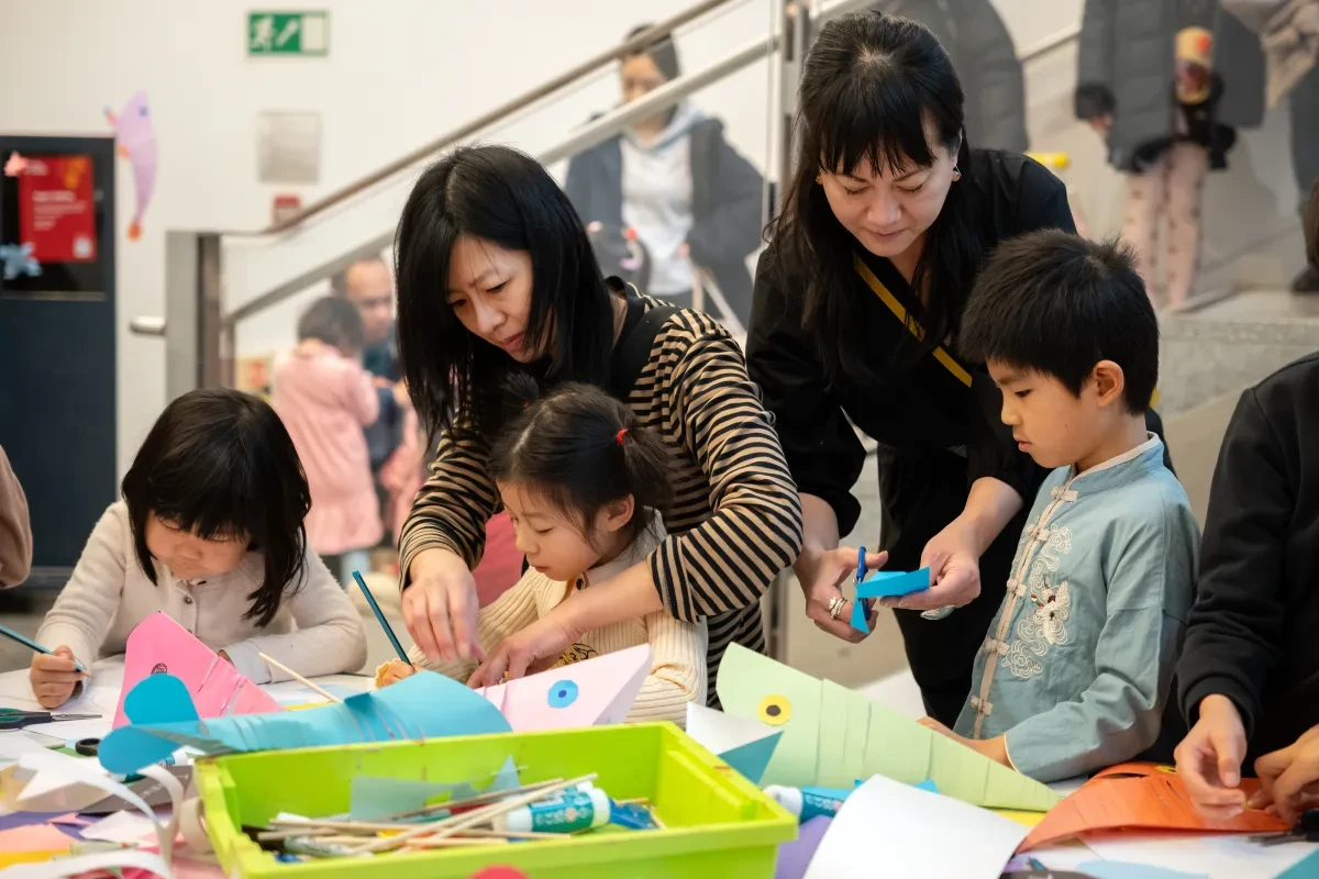Two mums and three kids get stuck into craft activities at the Lunar New Year celebrations at the National Maritime Museum