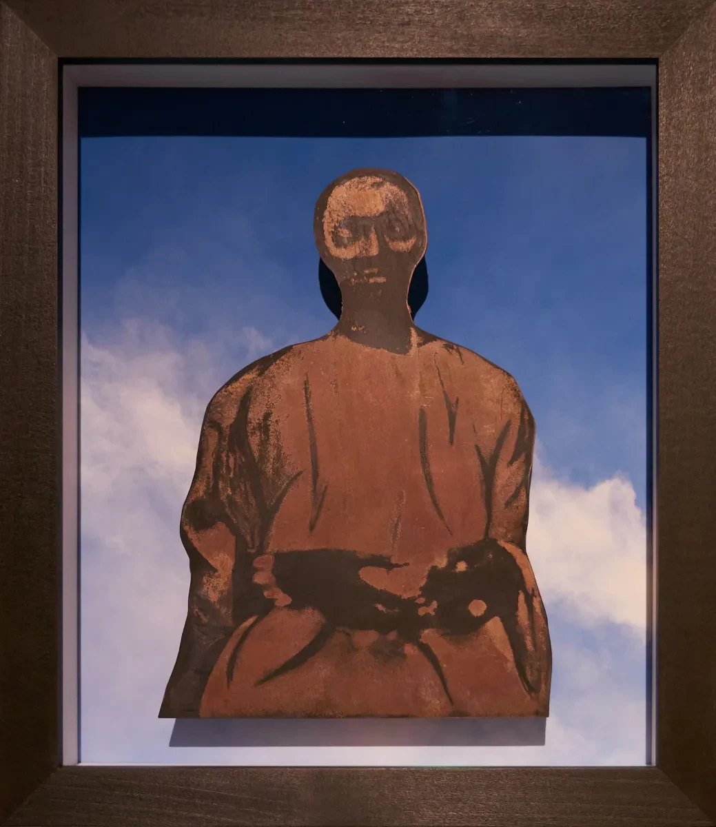 A historic photograph of a woman against a blue sky