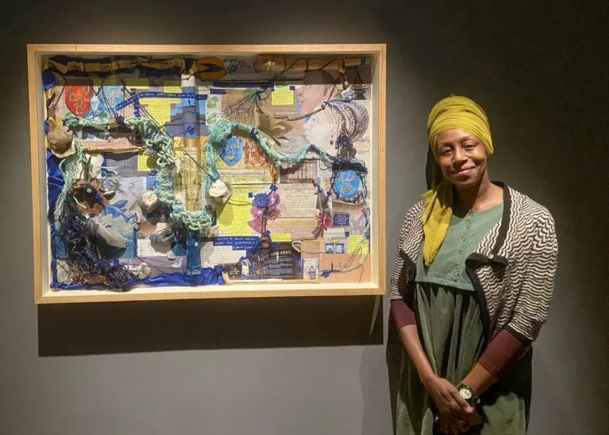 Artist Remiiya Badru stands next to The Rhumblineage of Penelope Steel on display in the Queen's House