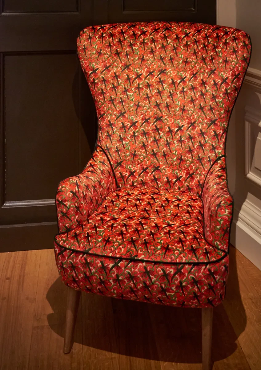 A red armchair adorned with designs of flying fish