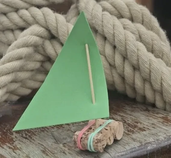 Small boat made of cork with a green sail