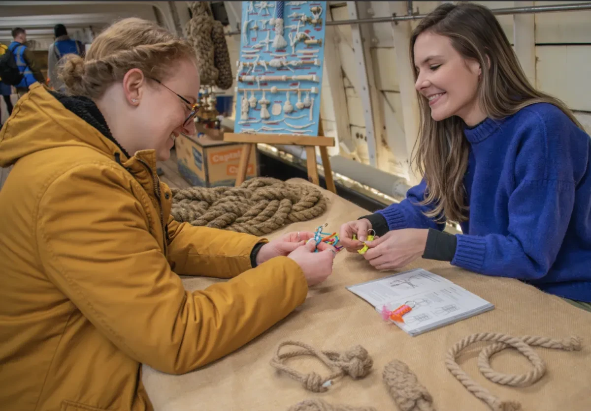 Photo of two women smiling at table with coils of rope on it