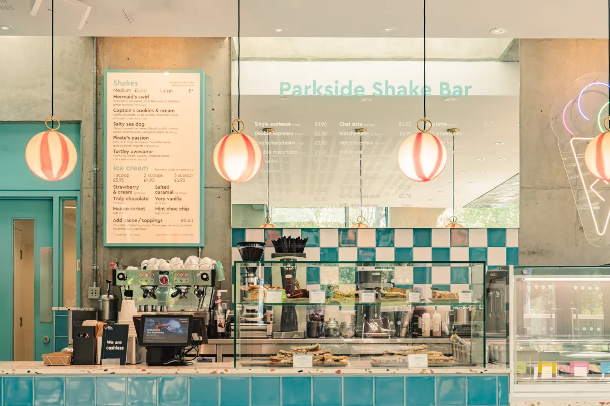 A bright cafe counter lit with red-and-white striped lights with blue-and-white checked tiles at the back