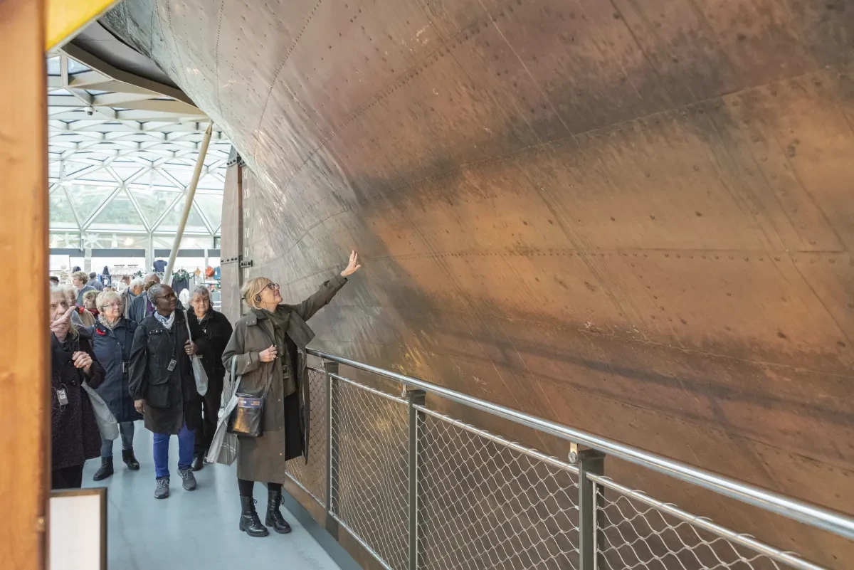 Visitor touches cutty sark hull during group tour