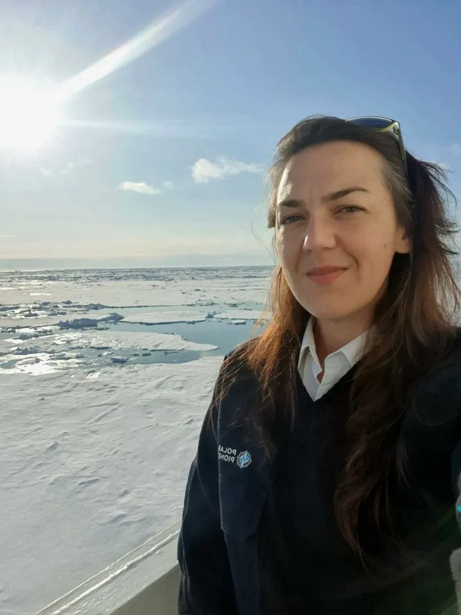 Captain Philippa Bowden next to gleaming ice in Arctic