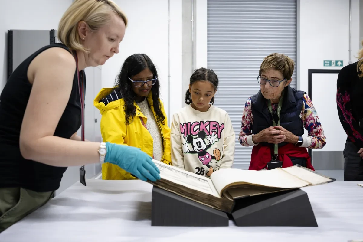A tour group look at an historic book