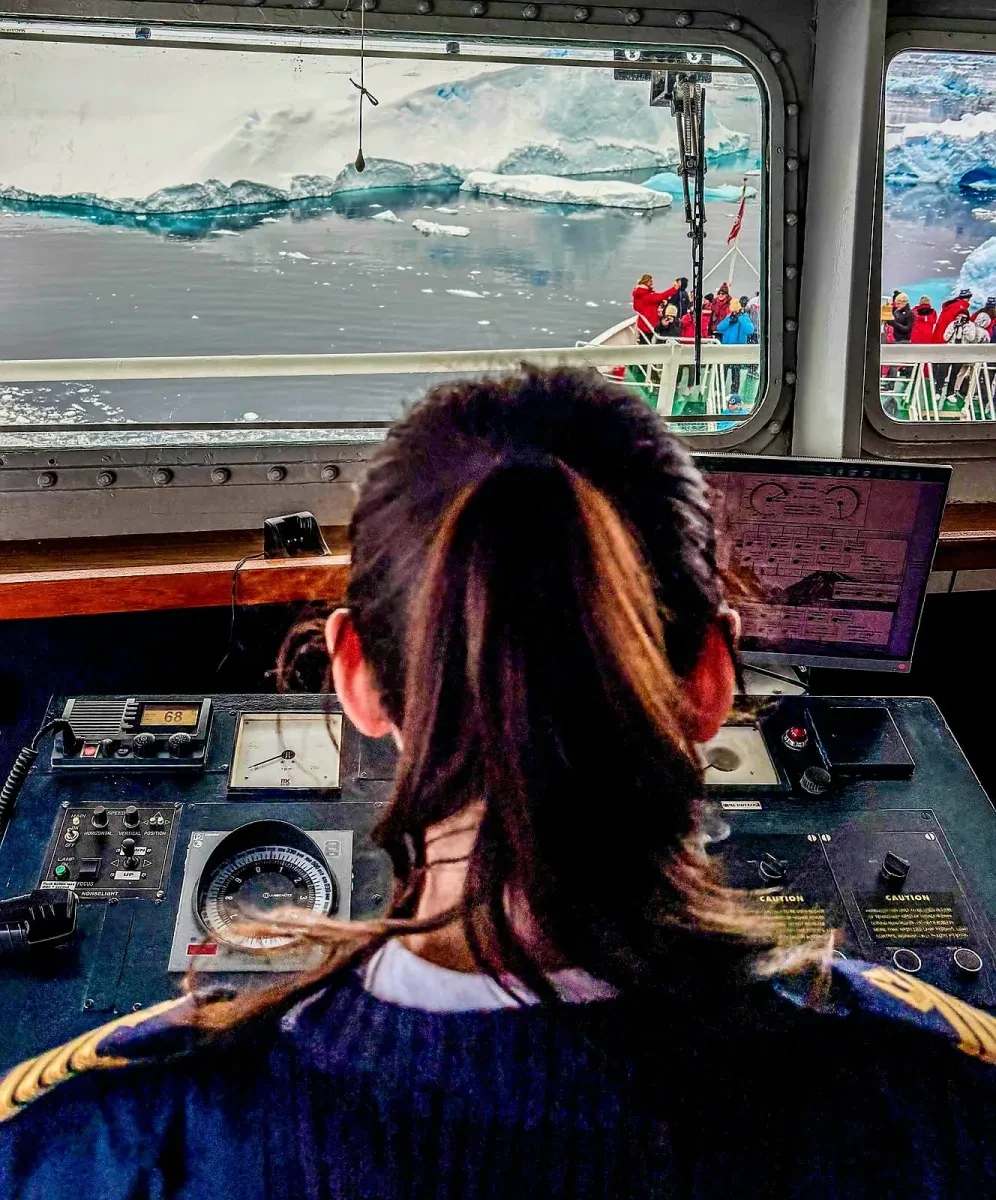 Shot taken from behind Captain Philippa Bowden showing her navigating a vessel