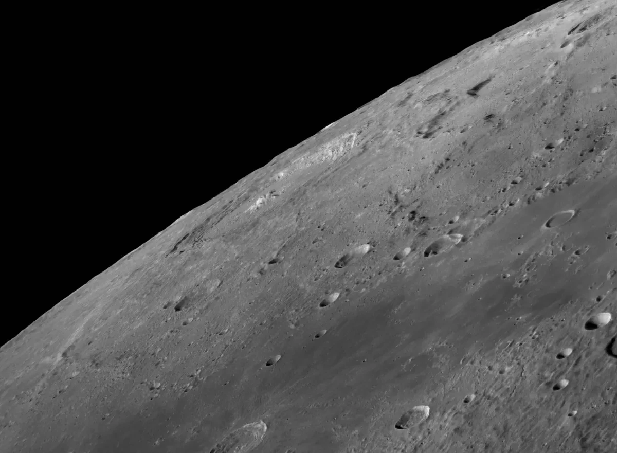 Close up of the curved limb of the Moon, with craters, valleys and alps on the lunar surface rendered in detail