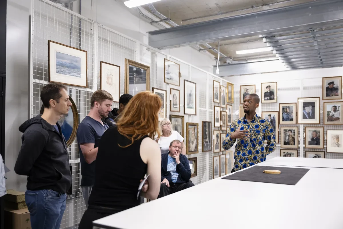 people standing around a table listening to a man speak 