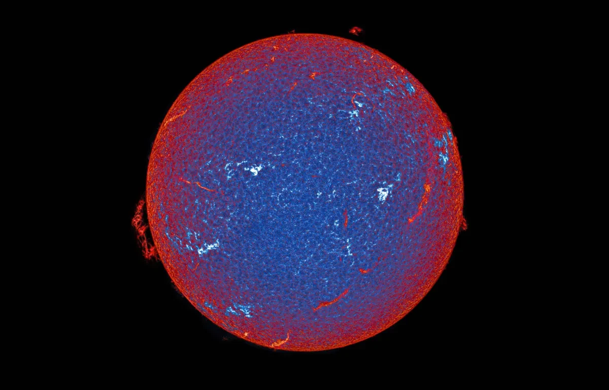 A blue orb with a red outline and red and white streaks sits in a black sky; with small red clouds emitting from three separate spaces on the outer rim. Part of ZWO Astronomy Photographer of the Year competition 2026 