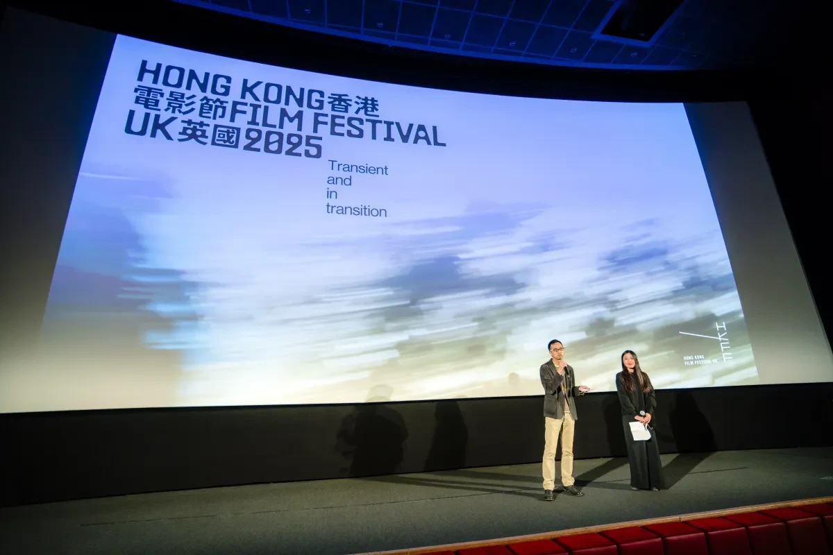 photo of a stage with a projected backdrop and two people standing on the stage