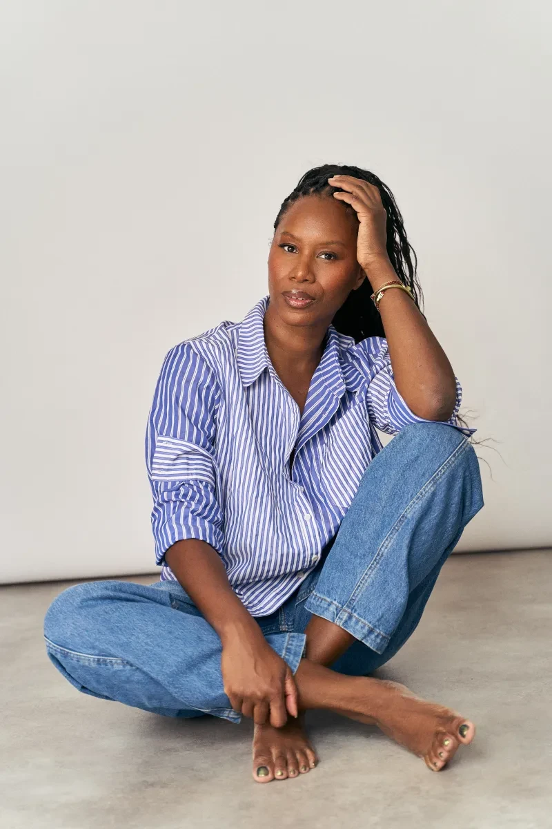 Photo of Aicha McKenzie sitting on the floor cross-legged