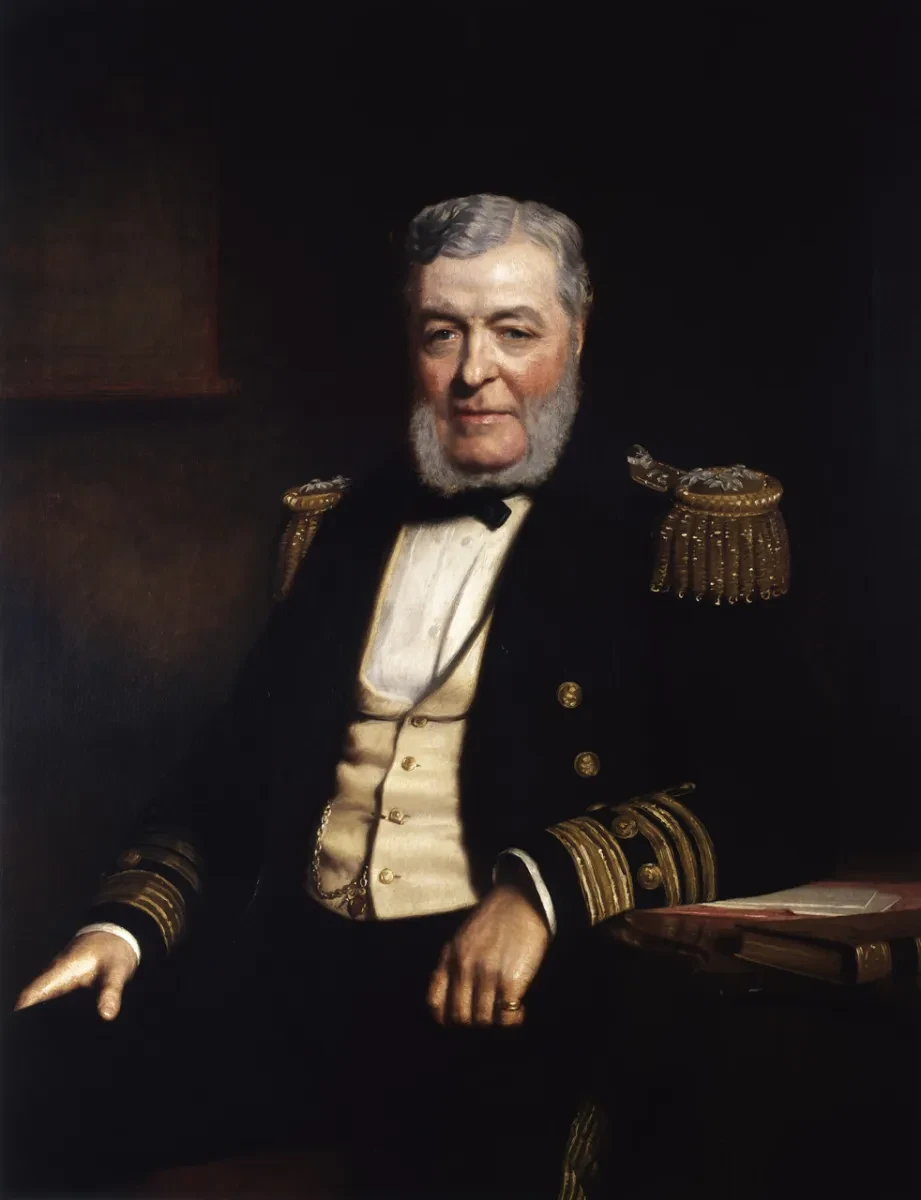 A painting of an Admiral wearing his official jacket with epaulettes, a cream waistcoat, a white shirt and a black bowtie. He has grey hair and a grey beard the covers just his cheeks and chin, plus a thoughtful, wise expression