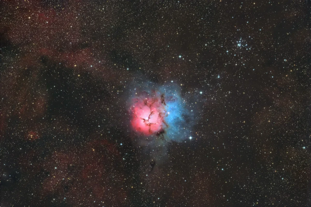 Pink and blue nebula surrounded by stars