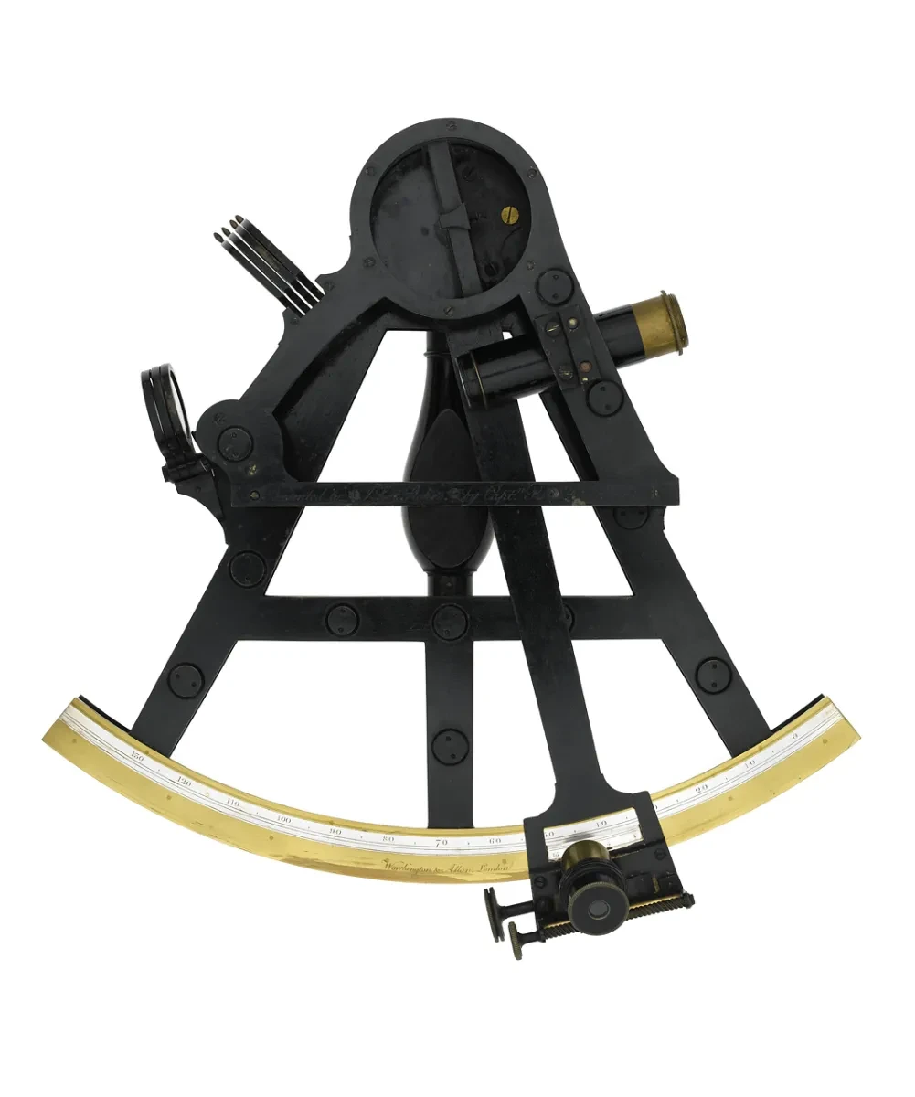 A black and gold triangular instrument called a sextant with several moving parts