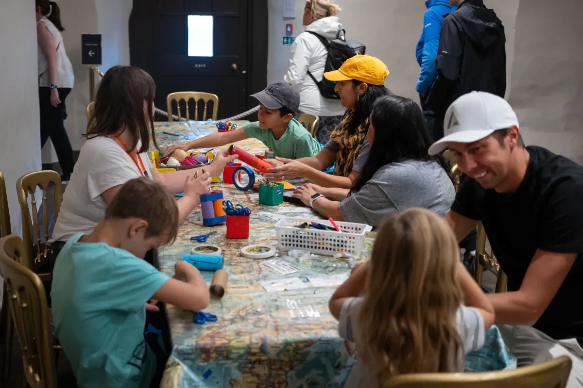Table of people in historic house Undercroft doing a craft activity