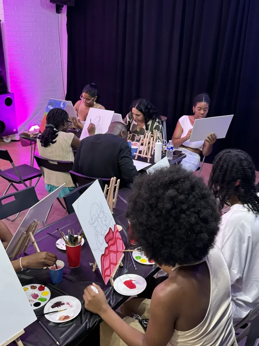people sitting and painting on canvas