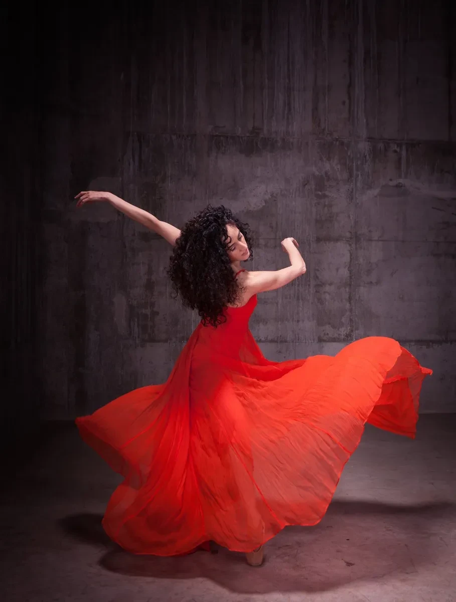 A dancer twirls in a red dress
