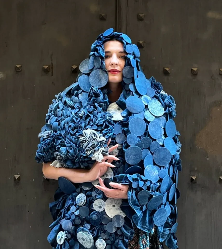 Image of a person dressed in an outfit adorned with blue buttons