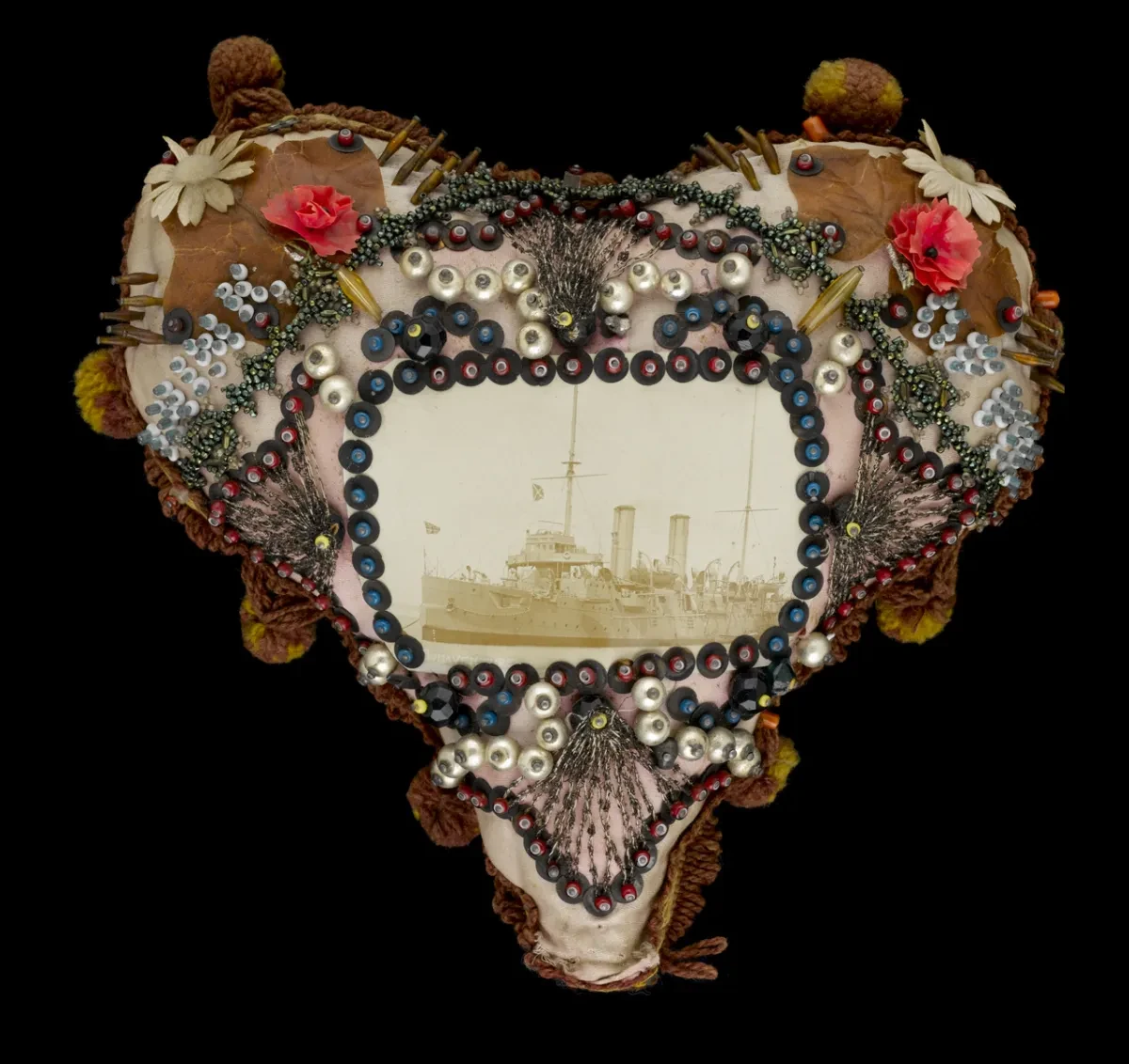 photo of a heart shaped hand, crafted pin cushion. with sequins and a photo of a ship in the middle