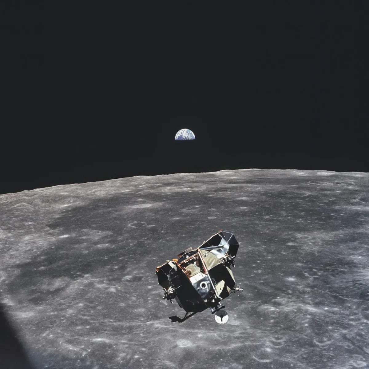 Apollo 11 lunar module with the Moon and Earth in frame.