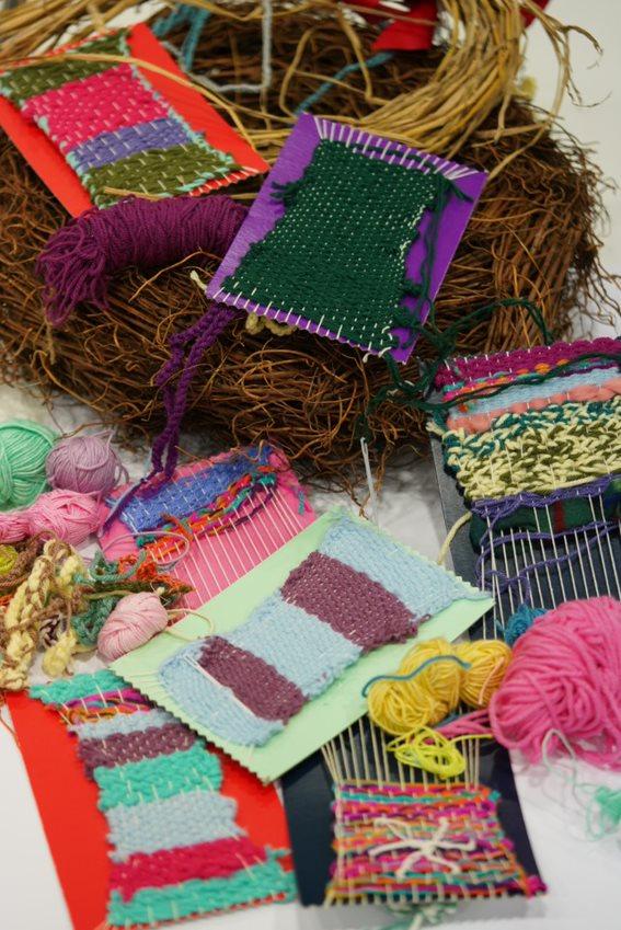 a mix of weaving boards with wool weaved on