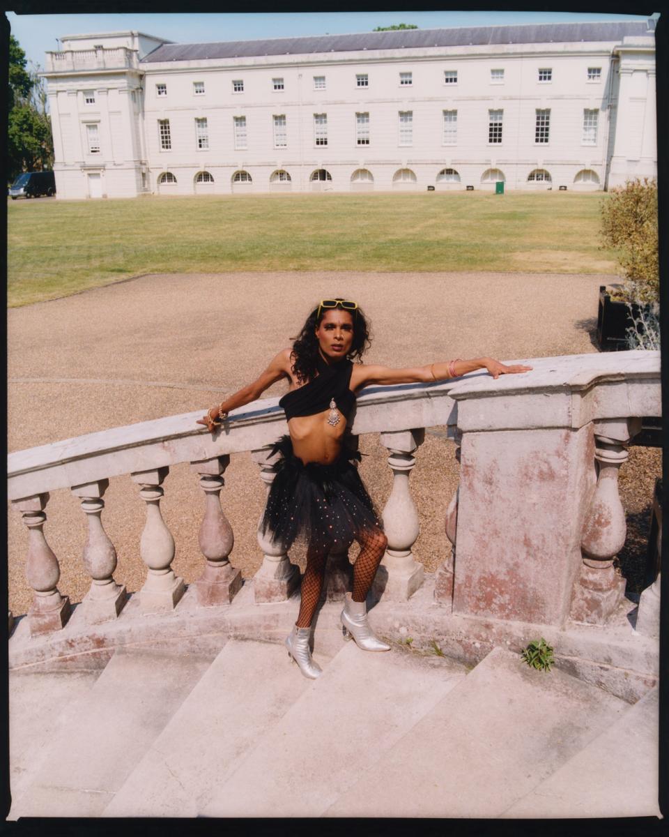 Portrait photograph of drag artist Bolly Illusion, posing on the steps outside the Queen's House in Greenwich