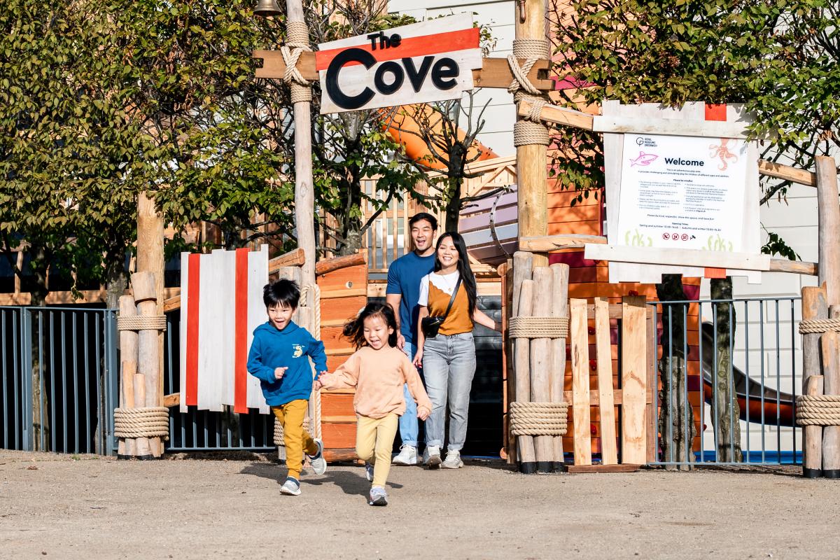 A family made up of a boy and girl, mother and father walk out of 'The Cove', the National Maritime Museum's maritime-themed outdoor playground