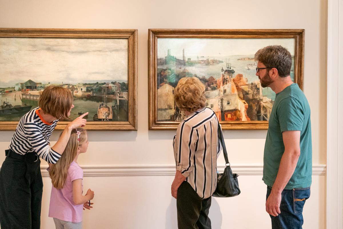 A group of people point at a painting