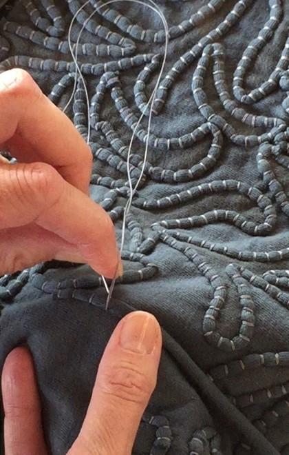 Hands sewing a piece of fabric