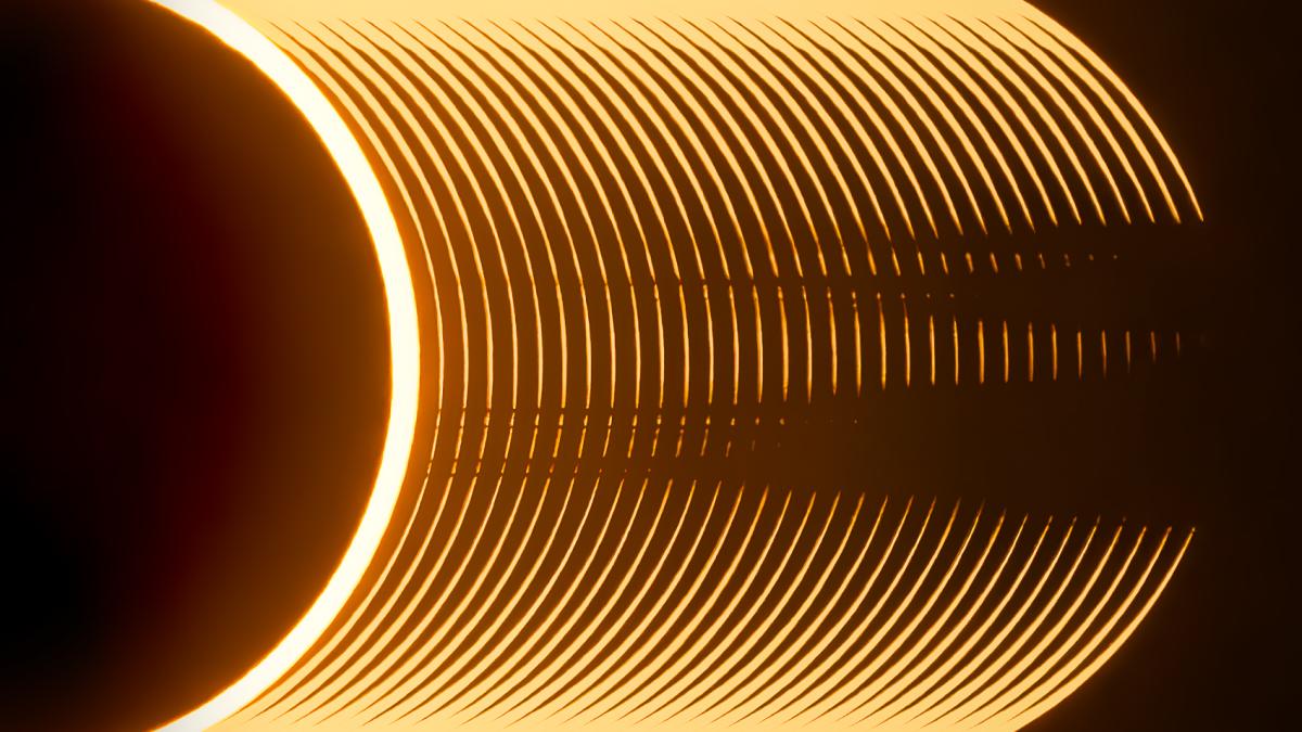 A sequence of telescope images stacked together to show the progression of a solar eclipse. A black semi-circle is visible on the left, with bands of yellow marking the changing amount of light as the Moon passes in front of the Sun