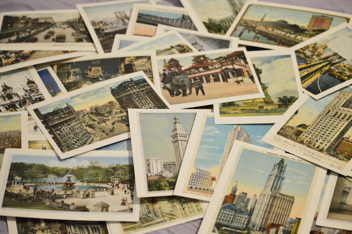 Photo of lots of vintage postcards depicting travel scenes overlapping