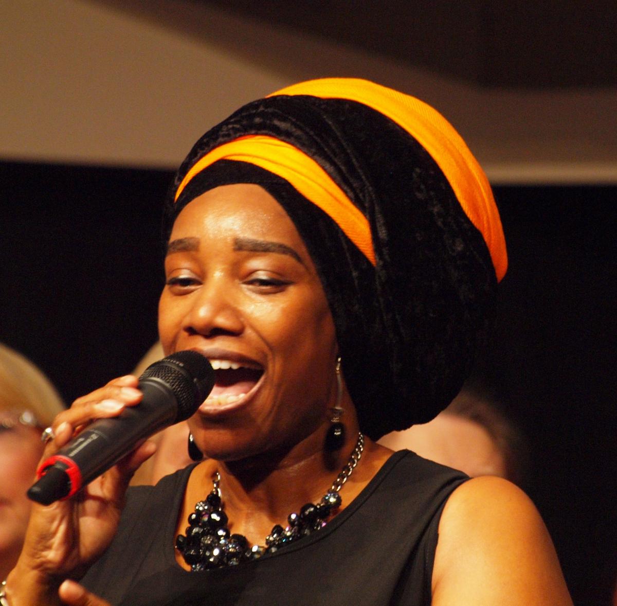 Photo of CeCelia singing into a microphone