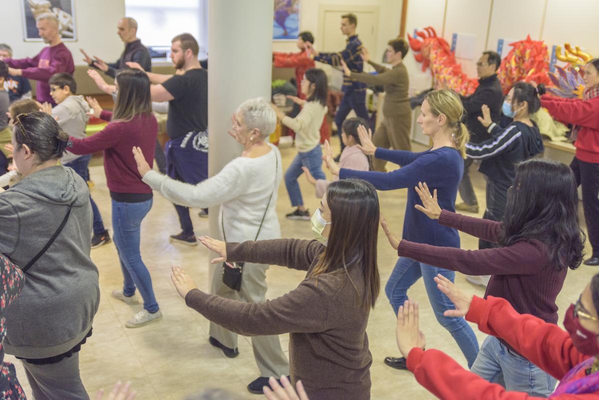 A group of people stretch their arms to the side
