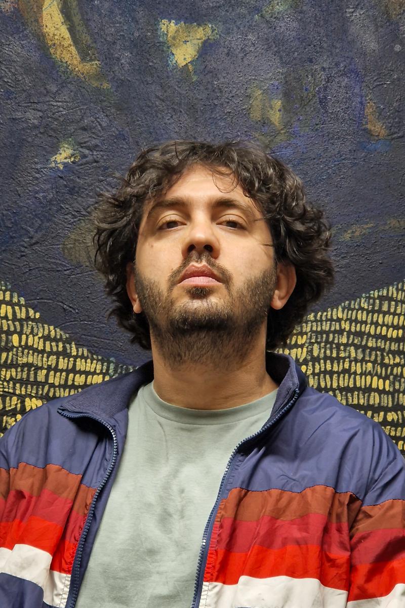 Headshot of Alaa Shasheet wearing a colourful jacket
