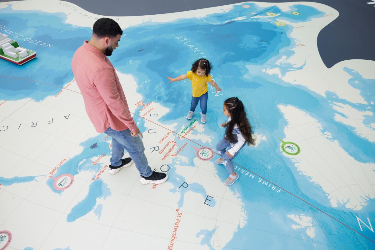 Father and daughters playing on the Ocean Map